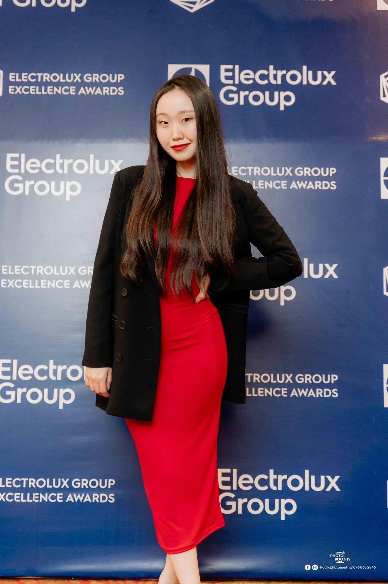 An AIESEC delegate at a corporate partner gala with branded backdrop